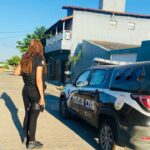 Policial civil ao lado de viatura da PCMG.