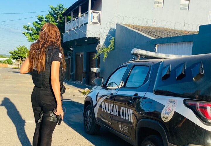 Policial civil ao lado de viatura da PCMG.