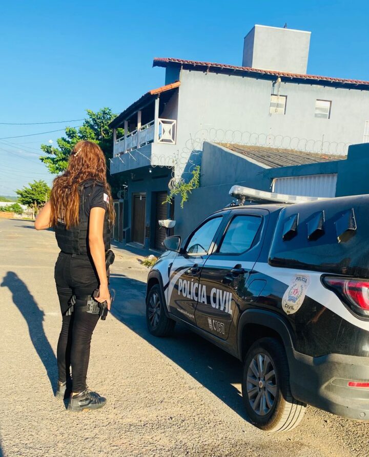 Policial civil ao lado de viatura da PCMG.